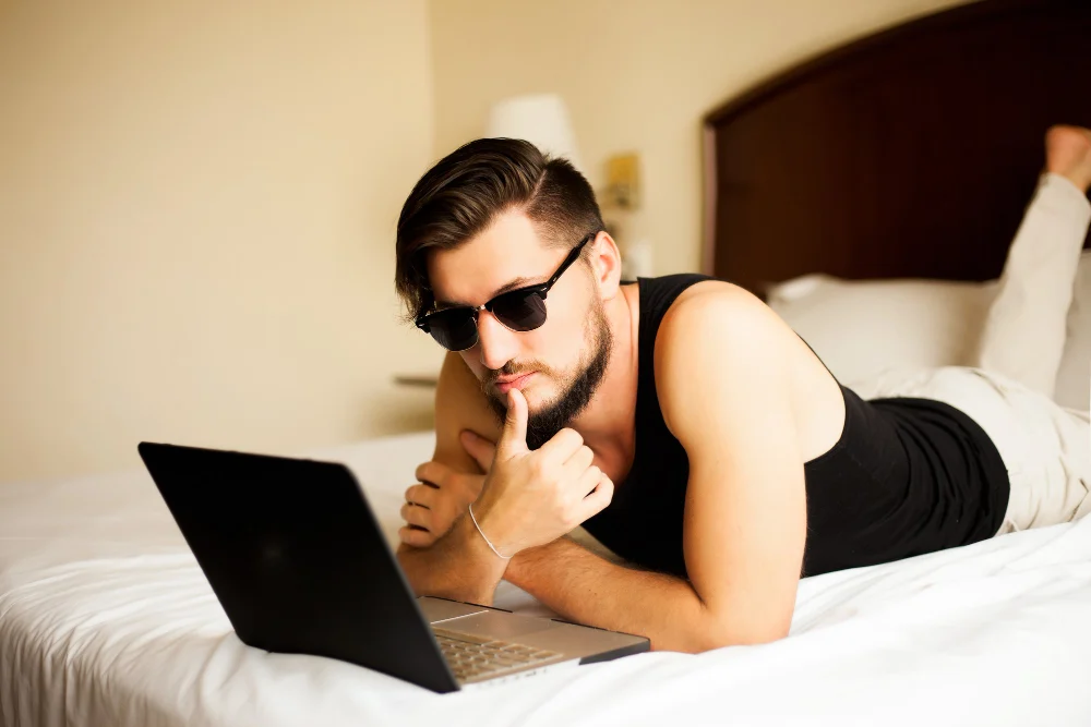 hübscher mann sucht nach escorts in der nähe auf seinem laptop